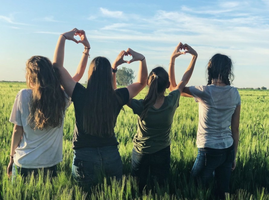 women forming heart gestures during daytime