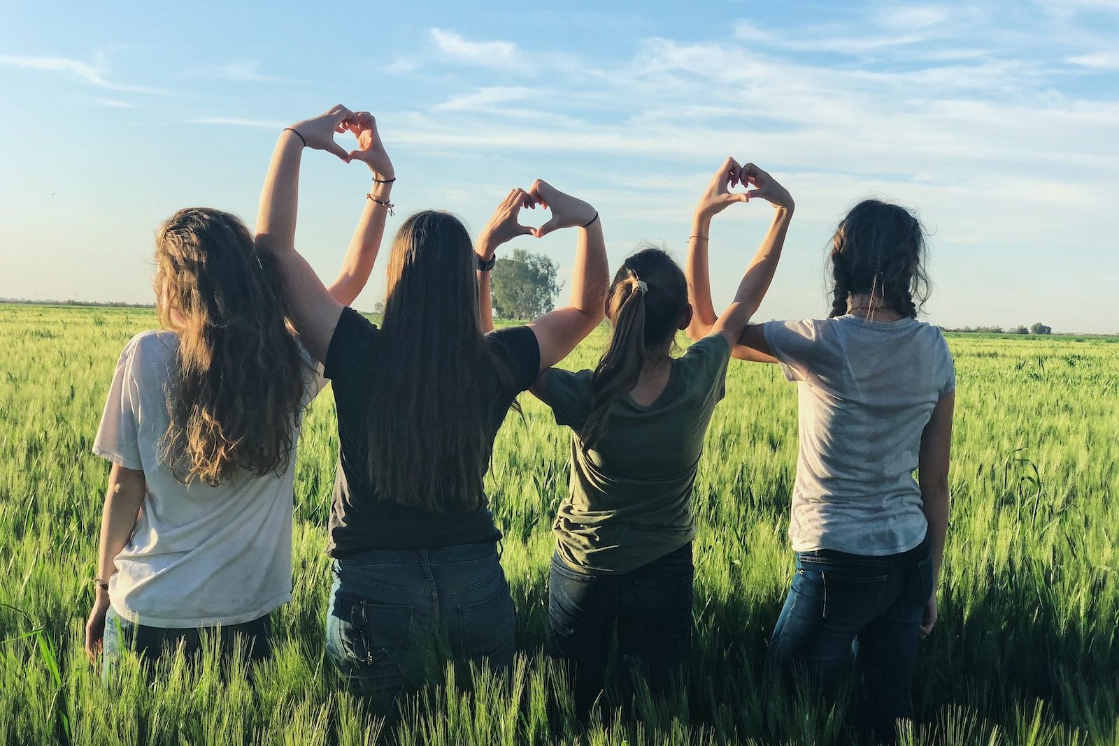 women forming heart gestures during daytime
